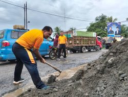 Bersama Warga, Personil Polsek Tanjung Pura Timbun Jalan Berlubang Demi Cegah Laka Lantas